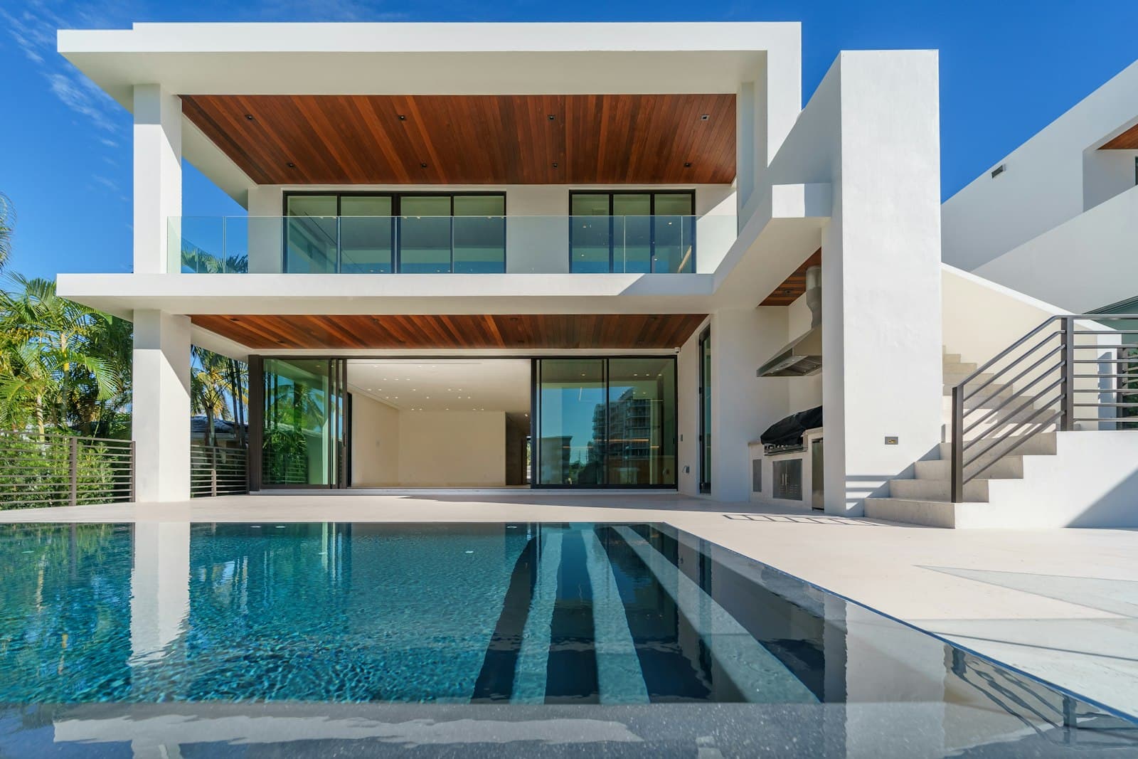 White villa with a pool and floor-to-ceiling glass